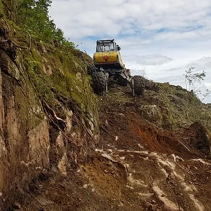 Menzi Muck klatregravemaskin i bratt fjellvegg