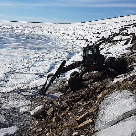 Menzi Muck i arbeid ved islagt vann